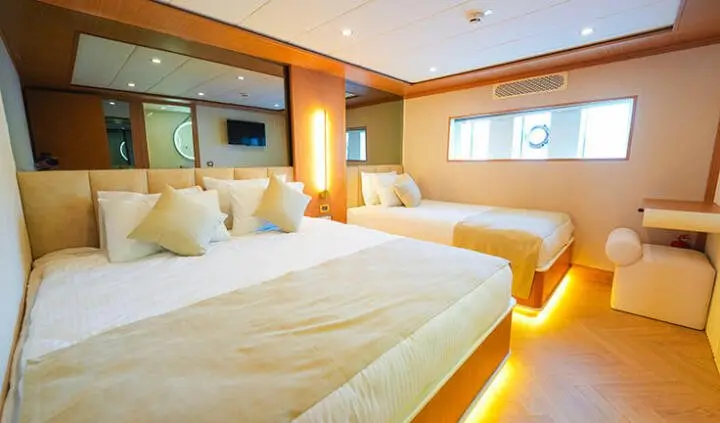 King Of The Sea cabin with two white beds and warm ambient lighting