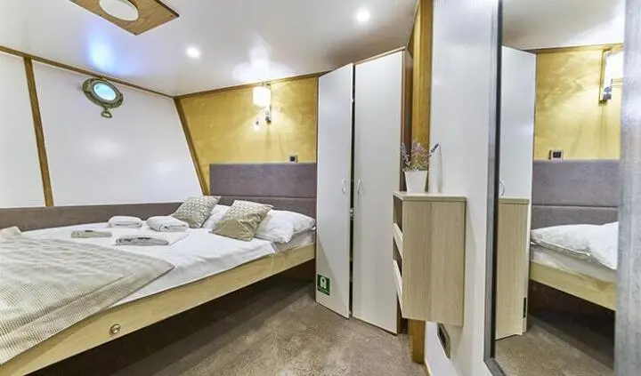 Romanca yacht cabin with two single beds, wood paneling, wardrobe, and ensuite door