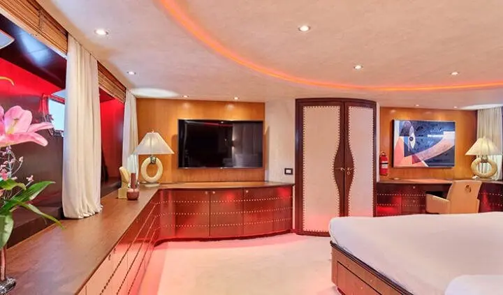 Mobius yacht cabin with king bed, ensuite area visible and warm wood interiors