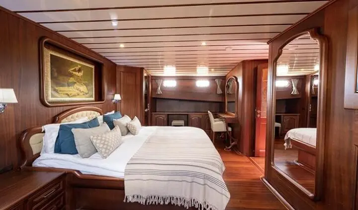 Master cabin with king bed, wood paneling, and ensuite area visible