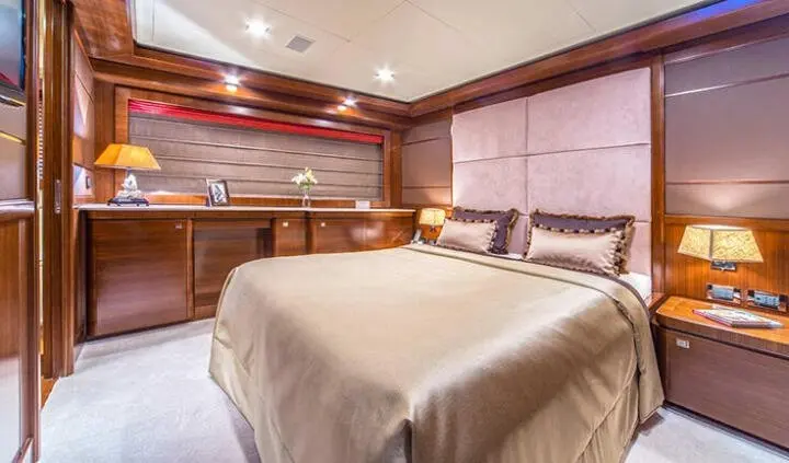 Seventh Sense master cabin with king bed, ensuite glimpse and warm wood accents