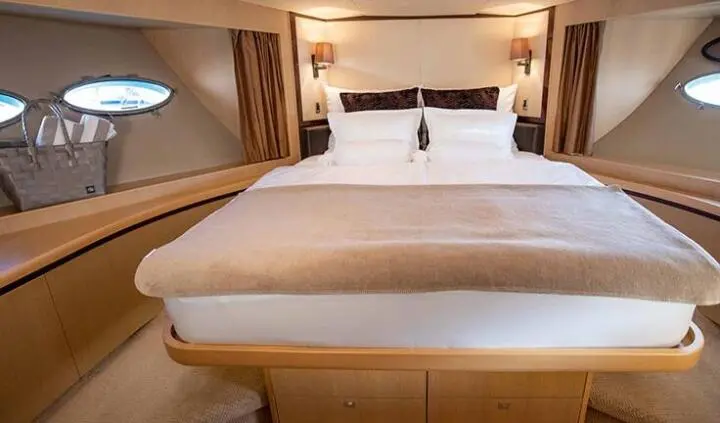 Master cabin with king bed, beige linens, wood cabinetry, and ensuite visible
