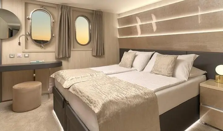 Cruise cabin on Cristal yacht with two beds, circle window, beige decor