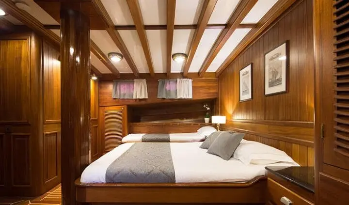 Carpe Diem 7 master cabin with king bed, wooden overhead beams, and ensuite hints