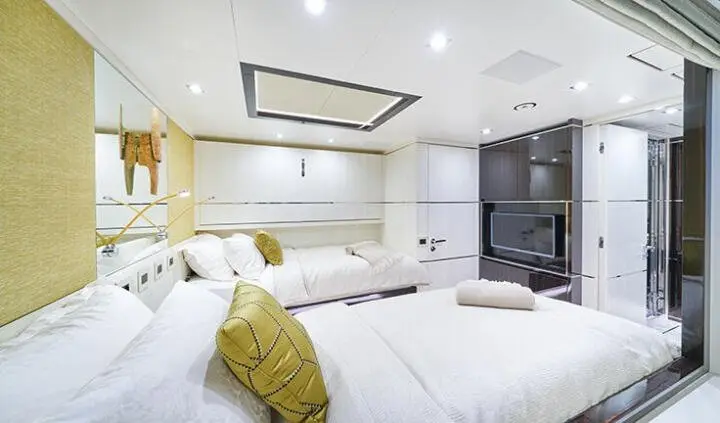 Twin cabin ensuite designer yacht interior with beds, white decor, and skylight