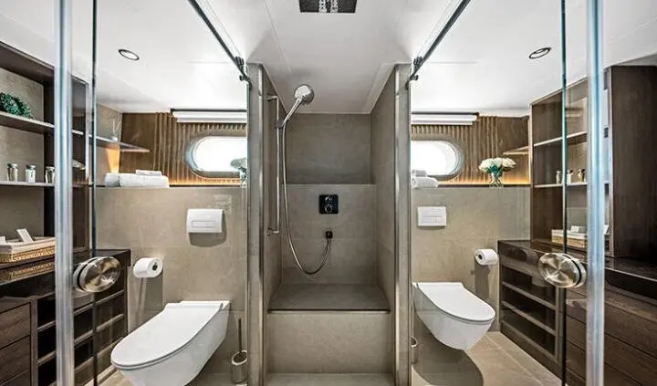 Master cabin with king bed, ensuite, wood panels, soft lighting, and angled seating areas