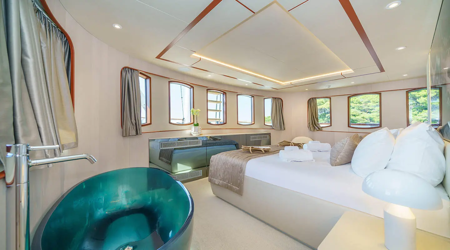 VIP cabin on a yacht with a large bed and multiple windows, modern decor