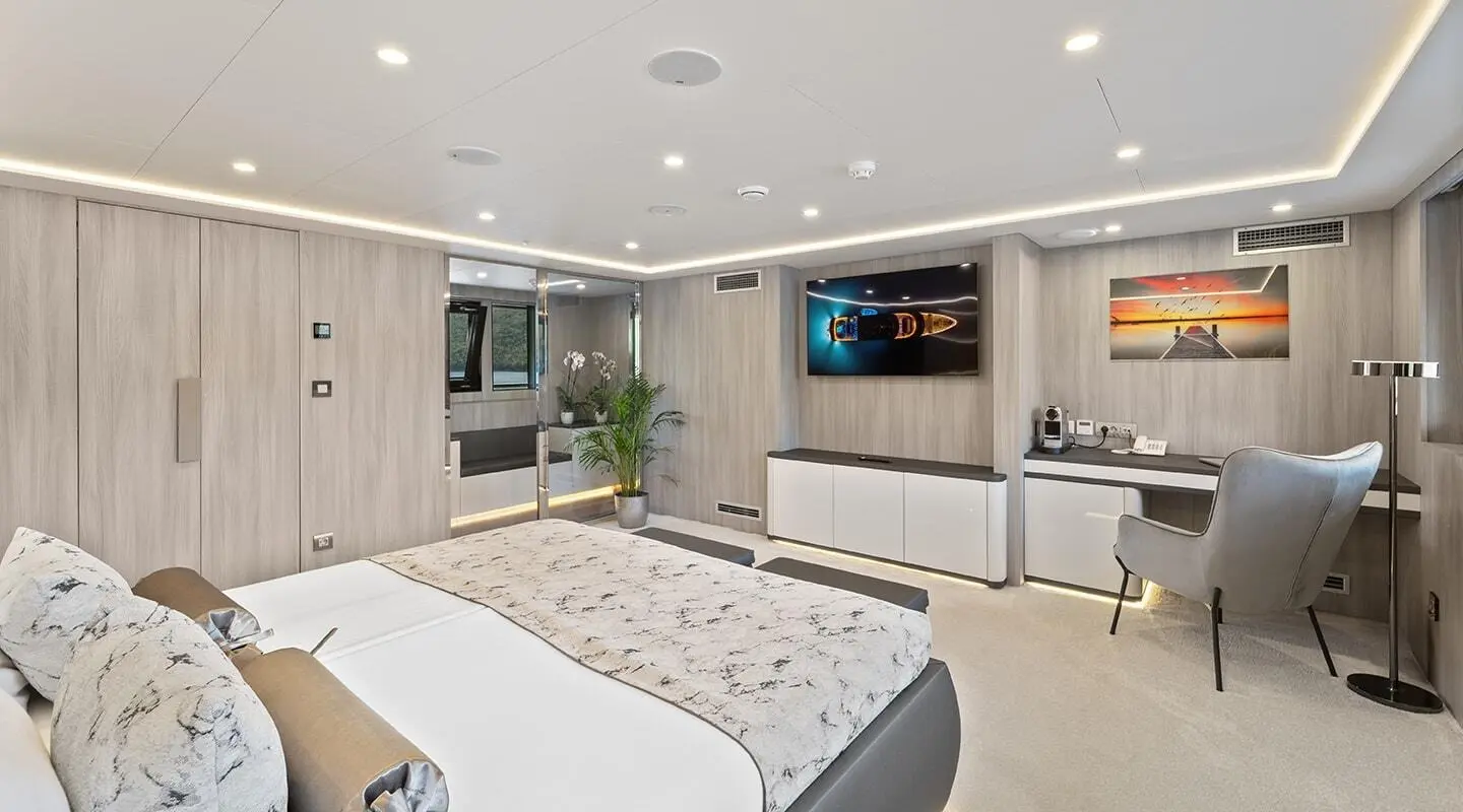 Luxurious yacht Freedom interior with large bed, TV, and seating area