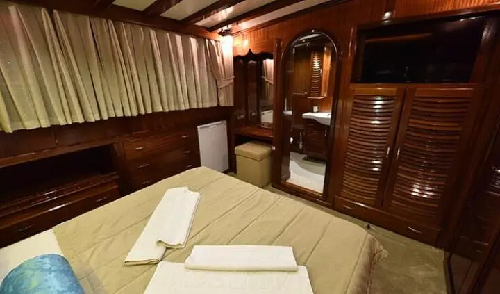 Cozy cabin with wood paneling, bed, and built-in storage on Kayhan Kaptan yacht