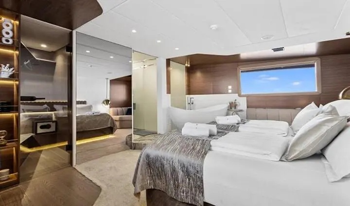 Master cabin with king bed, ensuite, and seating area on Bella yacht