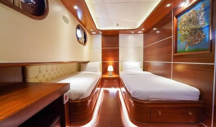 Interior cabin of La Bella Vita yacht with two beds and wood paneling