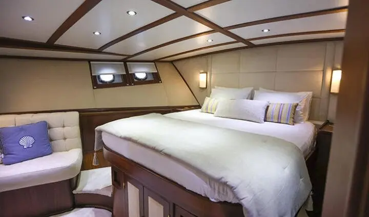 Gazella yacht master cabin with king bed and ensuite, warm wood interior