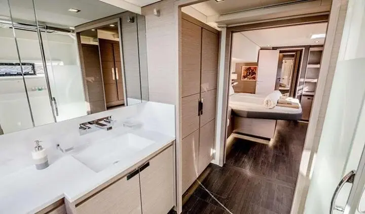 Astoria yacht cabin bathroom area with sink, mirror, and doorway