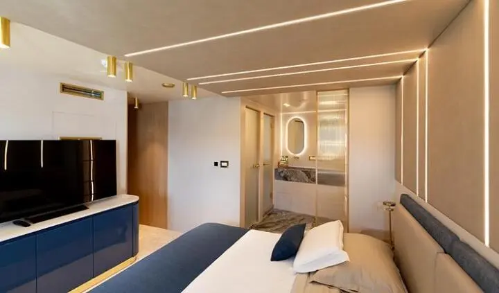 Master cabin with king bed, ensuite bathroom, soft lighting, neat decor