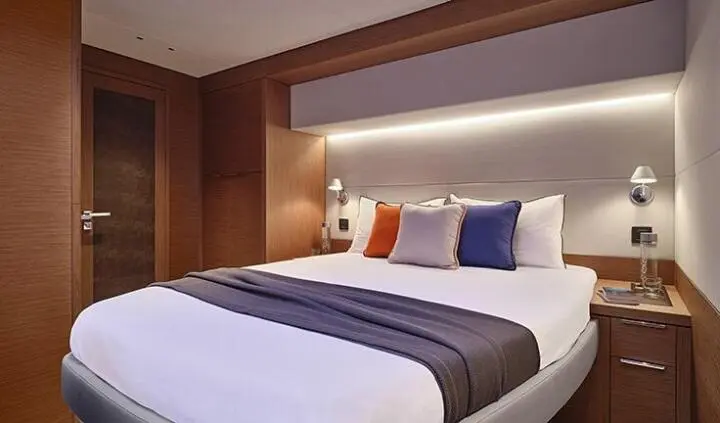 Daiquiri master cabin with king bed, white linens, and navy pillows