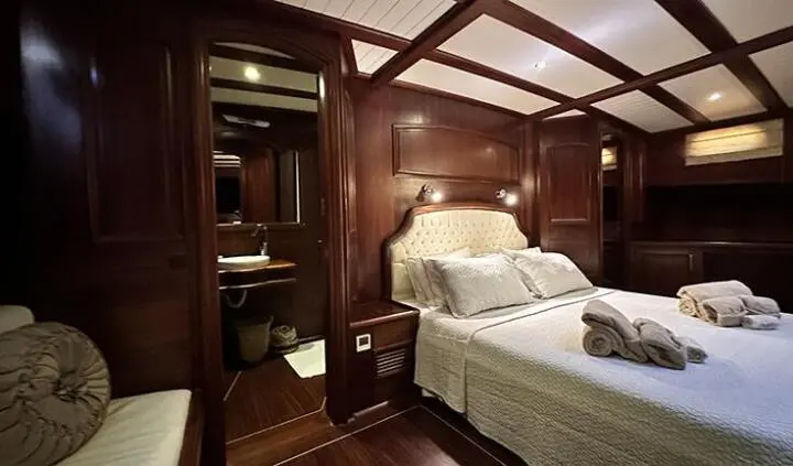 Master cabin with king bed, ensuite, warm wood panels and lighting