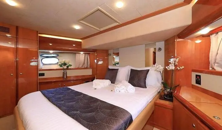 Quo Vadis I master cabin with king bed, white linens, wooden cabinetry