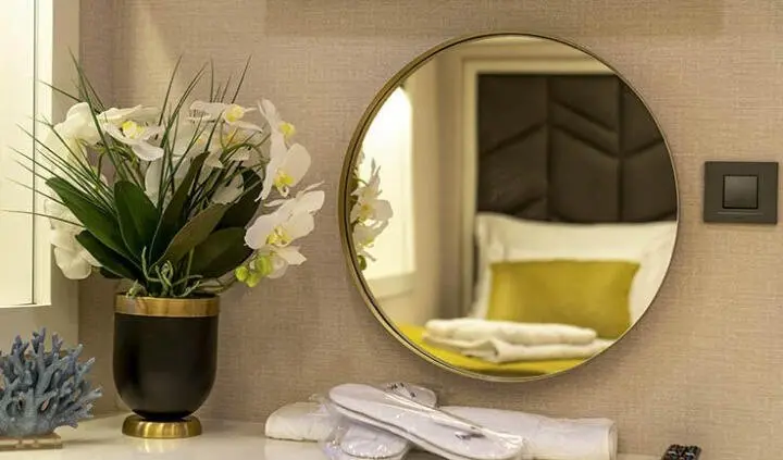 Queen Of Makri master cabin bed and en suite with circular mirror window