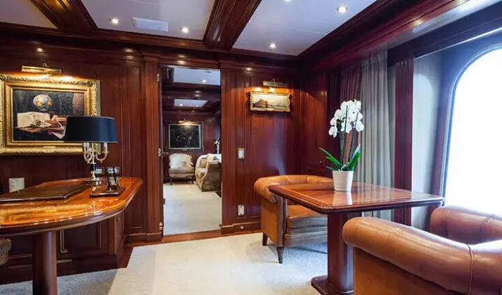Master cabin with king bed, wood cabinetry, and ensuite bathroom on yacht