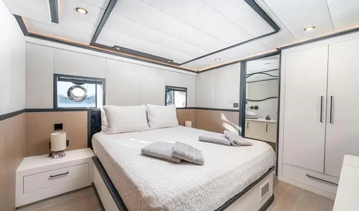 Calm Down yacht cabin with king bed, white linens, and ensuite doors
