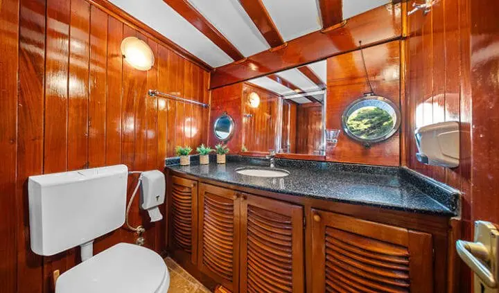 Elegant yacht master cabin with wooden cabinetry, curved desk, and ensuite bath area