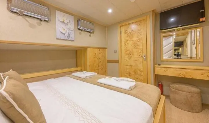 Belgin Sultan master cabin with large bed, wooden cabinetry, and soft lighting