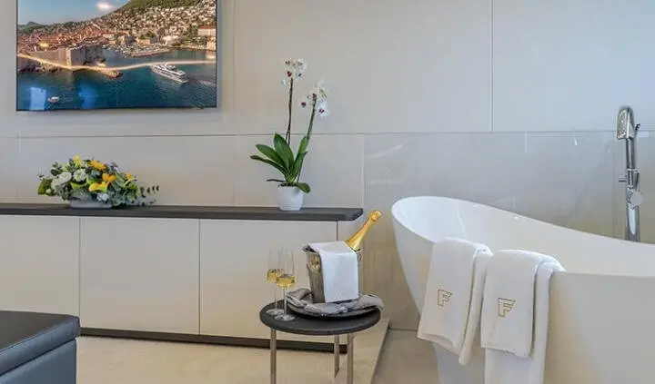 Master cabin with king bed, white cabinets, small table and plant