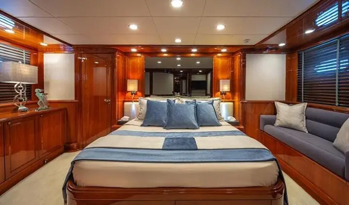 Divine master cabin with king bed, blue bedding, and ensuite glimpse