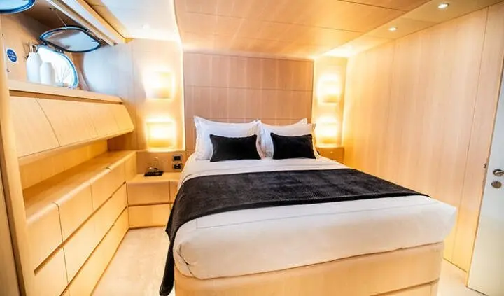 Pareaki II master cabin with king bed, dark bedding, wooden panel walls, built-in nightstands