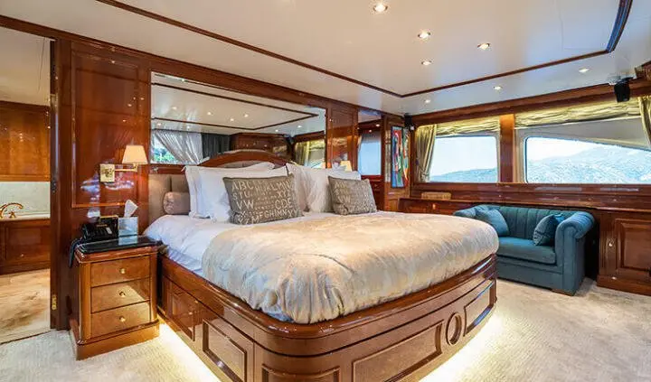 Amadea master cabin with king bed and wood-paneled walls, plush bedding