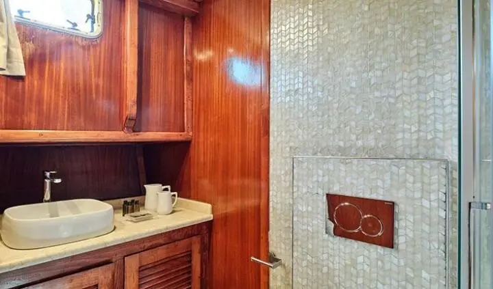 Master cabin with a king bed, wood paneling, ensuite bathroom door visible