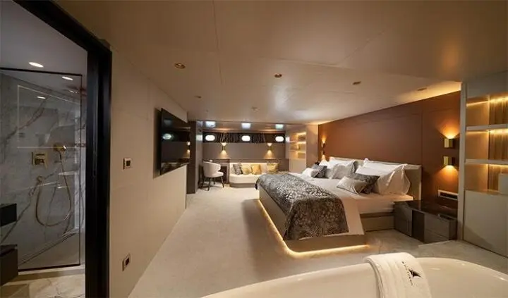 Nocturno cabin interior with king bed, plush bedding, and integrated ambient lighting