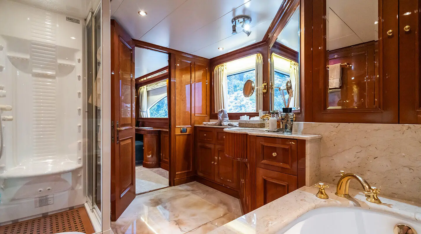 Bathroom aboard Amadea yacht with wooden cabinetry and marble countertop