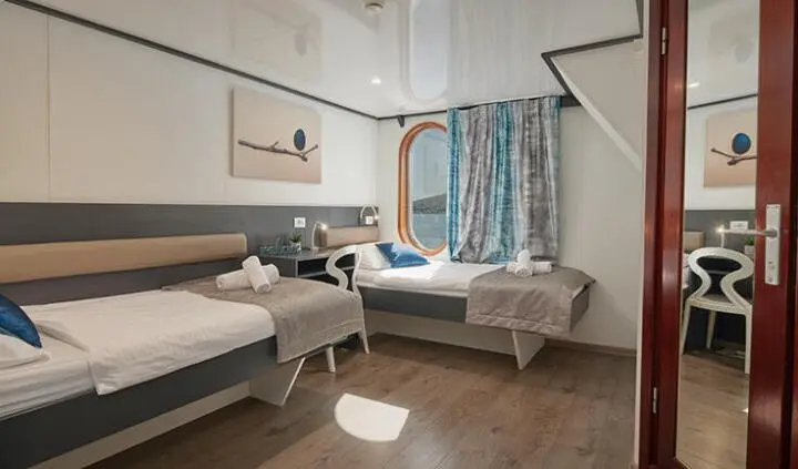 Twin-cabin boat nursery-like sleeping area with two beds and curtains