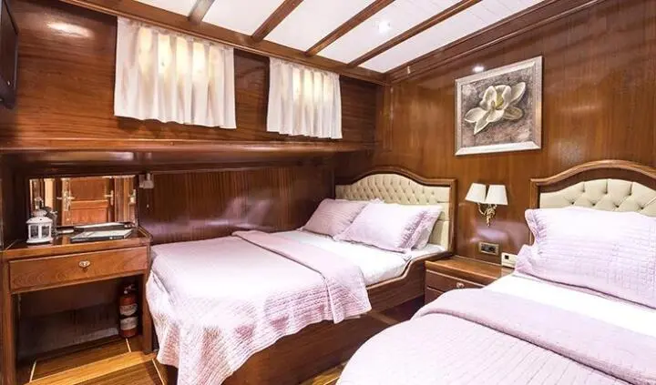 Twin cabin aboard Grace 1 yacht with two single beds and wooden interior