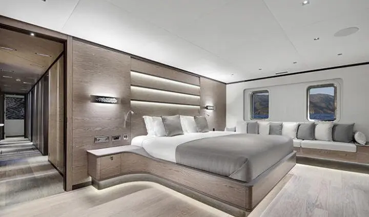 Master cabin with king bed, built-in headboard, nightstands, and ensuite door
