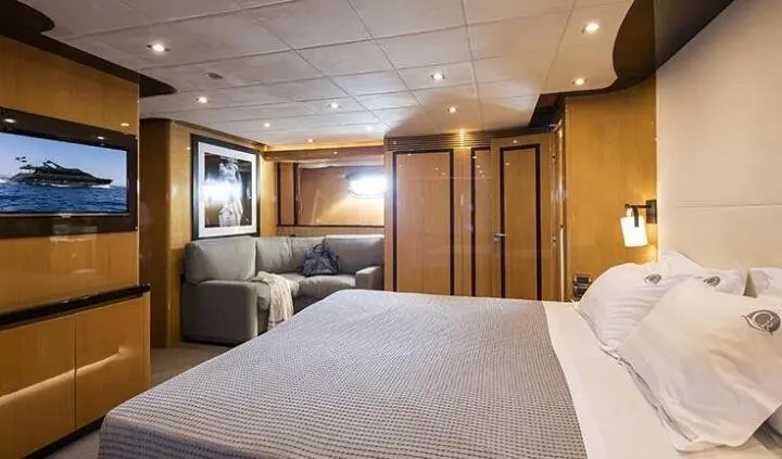 Master cabin with king bed, en suite, warm wood panels and seating