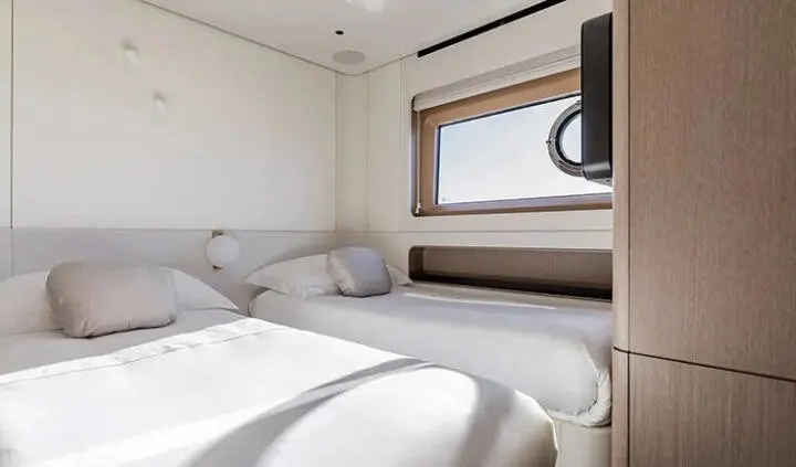 Twin cabin with two single beds, windows, and neutral decor on Viva II yacht