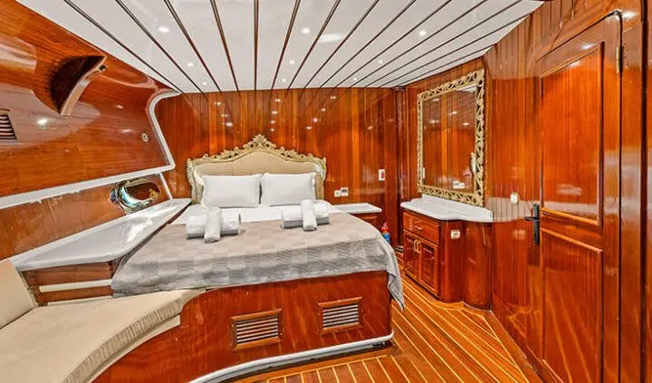 Esma Sultan yacht cabin with wooden paneling, double bed, bedside cabinets