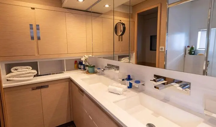 Cabin sink area on Serenissima yacht with beige cabinets and twin mirrors
