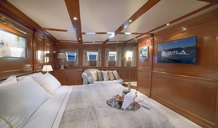 Aquila cabin interior with king bed, wooden paneling, and seating area