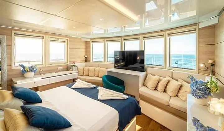 Riva yacht cabin interior with king bed, ensuite visible, warm wood tones