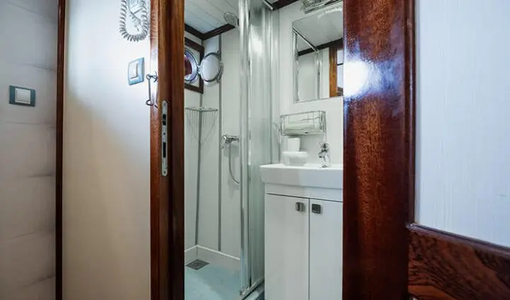 Yacht Mendula cabin with ensuite bathroom, compact shower, sink, and mirror