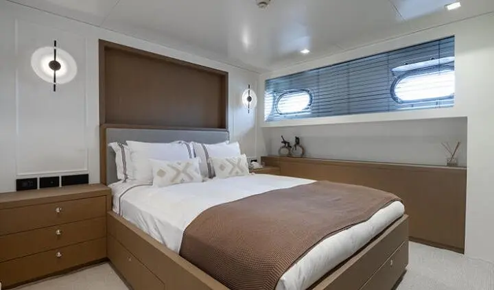 Illusion II master cabin with a king bed, brown bedding, and porthole windows