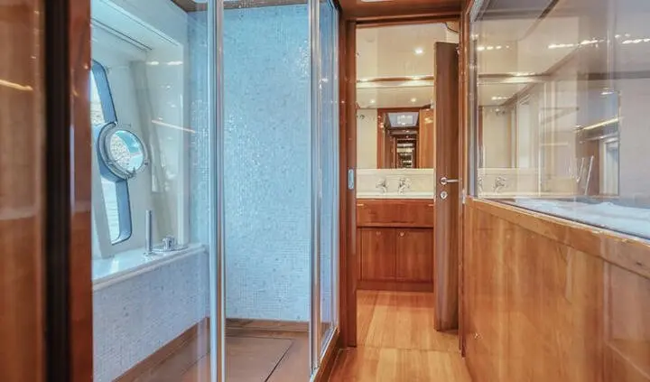 Master cabin with king bed, ensuite along wood paneling and polished floor