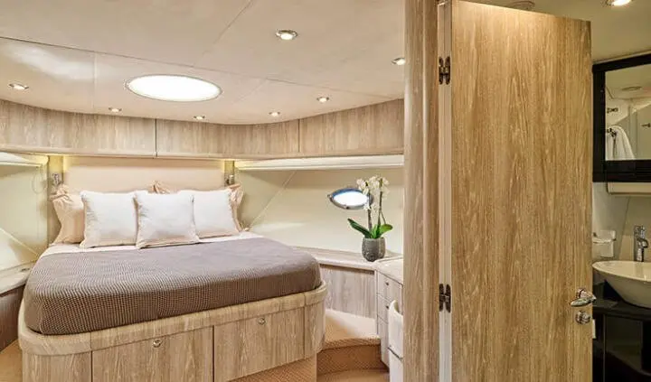 Master cabin with king bed, wood paneling, ensuite doorway and seating area