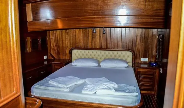 Master cabin with king bed and wooden panel walls on Enderim A