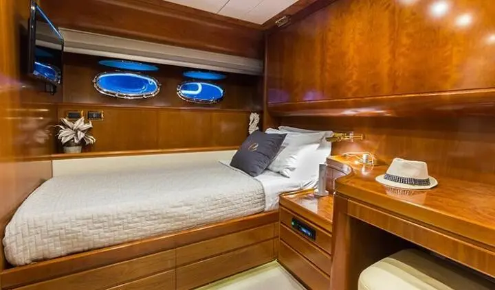 Master cabin with king bed and ensuite; wood panels, portholes, bedding and pillows