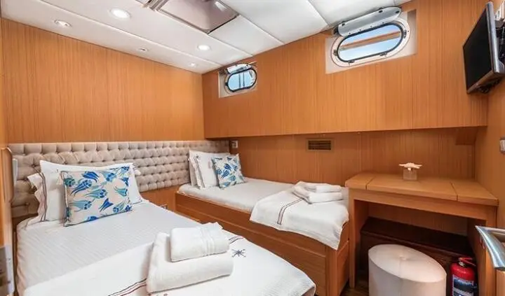 Artemis yacht cabin with twin beds, ensuite, wood paneling and porthole