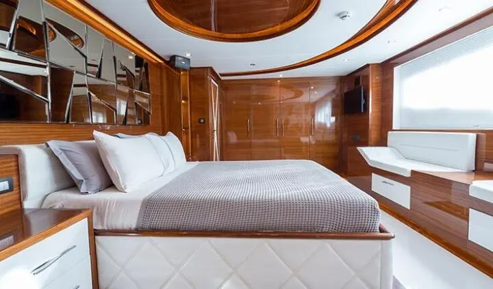 Master cabin with king bed, wood paneling, ensuite door, pillows and white bedding